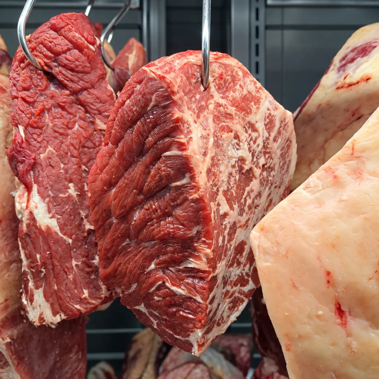 Peça de cupim bovino pendurada em vitrine refrigerada